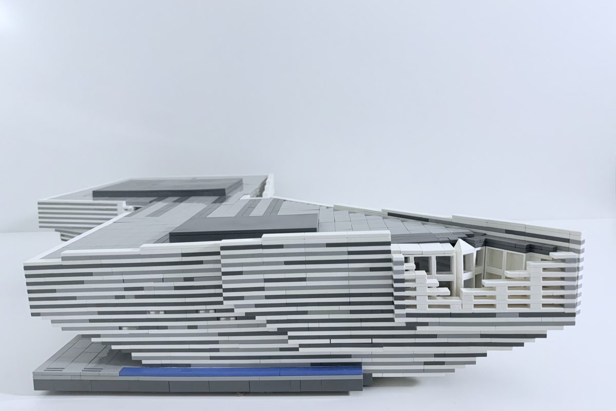 The LEGO model in profile, showing the cantilever and the windows along the upper floor